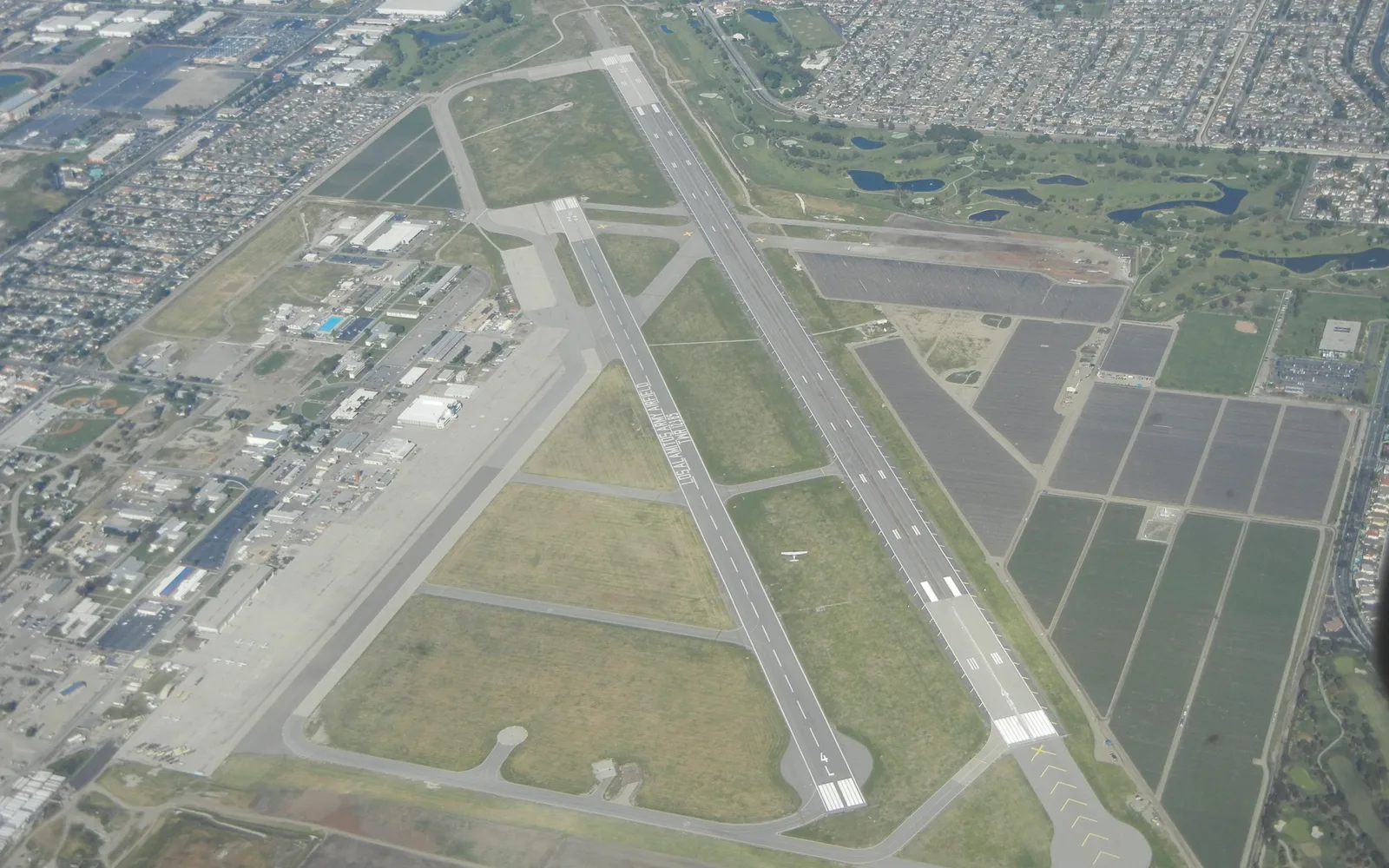 Aerial view of Los Alamitos Army Airfield showing long runway and airfield infrastructure against desert terrain